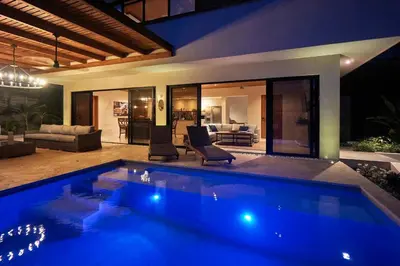 a swimming pool in front of a house at Casa Colibri - Stunning ocean view in Santa Teresa Beach