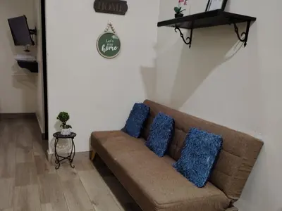 a couch in a living room with two blue pillows at SJO airport eco-Escape, Villa jr 2 & Pool in Tivives