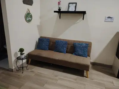 a couch in a living room with blue pillows at SJO airport eco-Escape, Villa jr 2 & Pool in Tivives