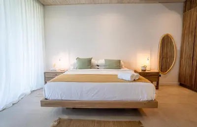 a bedroom with a large bed and a mirror at Mahalo Villas in Playa hermosa