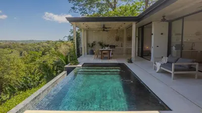 an infinity pool in the backyard of a house at Mahalo Villas in Playa hermosa