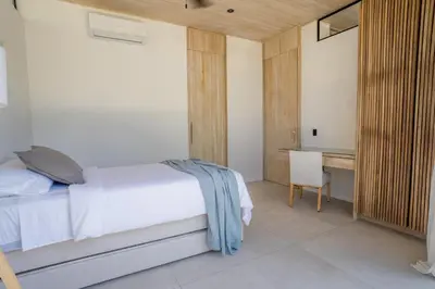 a bedroom with a bed and a desk with a chair at Mahalo Villas in Playa hermosa