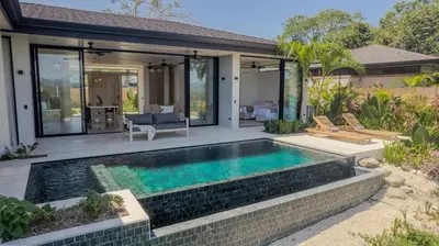 a swimming pool in the backyard of a house at Mahalo Villas in Playa hermosa