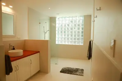 a bathroom with a sink and a shower with a window at Villa Paradise Garden in Cabuya