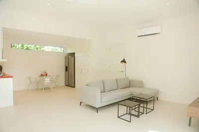 a white living room with a couch and a table at Villa Paradise Garden in Cabuya