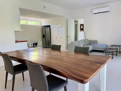 a large wooden table in a living room with chairs at Villa Paradise Garden in Cabuya