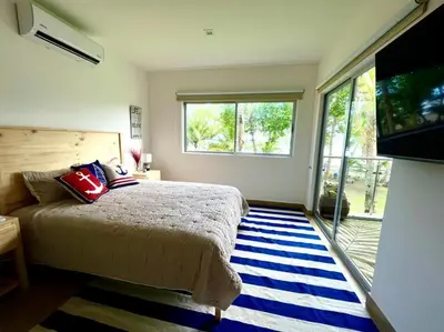 a bedroom with a bed and a large window at 2 Bedroom Oceanfront Condo with Wi-Fi, AC and Pool in Bejuco