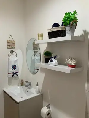 a bathroom with a sink and shelves with plants at 2 Bedroom Oceanfront Condo with Wi-Fi, AC and Pool in Bejuco