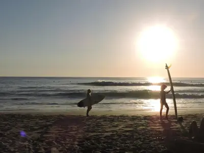 three people standing on the beach with their surfboards at Villa Primavera Santa Teresa Center- walking distance to the beach in Santa Teresa Beach
