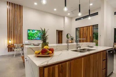 a kitchen with a sink and a bowl of fruit at New! Ocean View, Jungle Surrounded, Walk to Beach & River in Uvita
