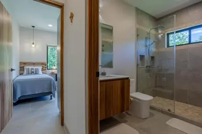 a bathroom with a shower and a toilet and a bed at New! Ocean View, Jungle Surrounded, Walk to Beach & River in Uvita