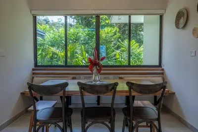 a dining room table with chairs and a vase with a flower at New! Ocean View, Jungle Surrounded, Walk to Beach & River in Uvita