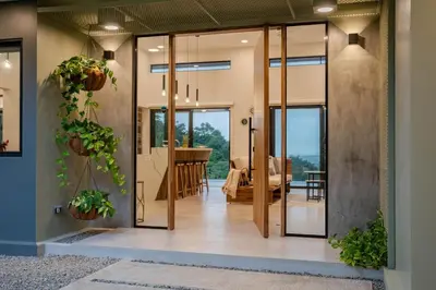 a pivot door in a home with a living room at New! Ocean View, Jungle Surrounded, Walk to Beach & River in Uvita