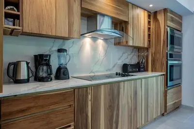 a kitchen with wooden cabinets and a blender on the counter at New! Ocean View, Jungle Surrounded, Walk to Beach & River in Uvita