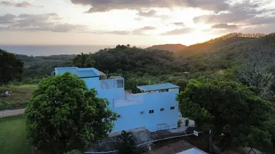 an aerial view of a white building in the trees at Casa Kairos CR, Playa Samara in Nicoya