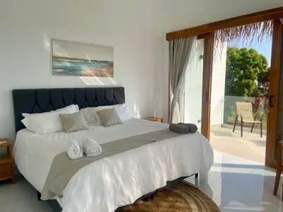a bedroom with a large bed with towels on it at Casa Kairos CR, Playa Samara in Nicoya