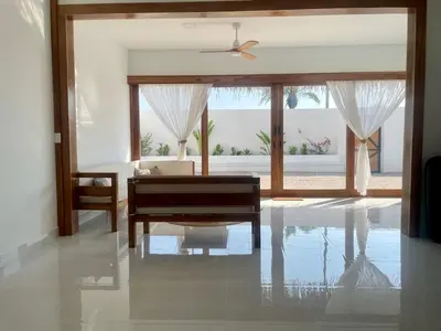 a living room with a table and a couch and a window at Casa Kairos CR, Playa Samara in Nicoya