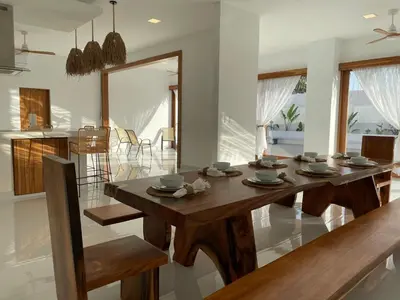 a kitchen and dining room with a wooden table at Casa Kairos CR, Playa Samara in Nicoya