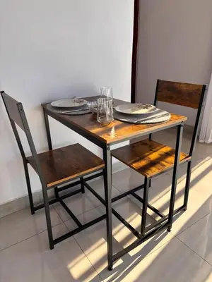 a wooden table with two chairs and a table with plates and glasses at Cabina Hermanas Valencia in Monteverde Costa Rica