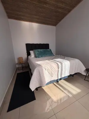 a bedroom with a bed with a black and white comforter at Cabina Hermanas Valencia in Monteverde Costa Rica