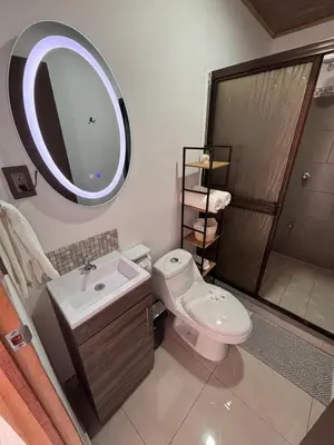 a bathroom with a toilet and a sink and a mirror at Cabina Hermanas Valencia in Monteverde Costa Rica