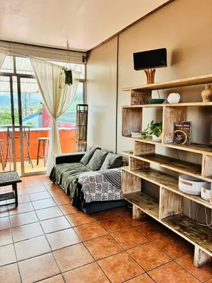 a living room with a couch and a tv at Boutique Hotel Casa de Lis, Turrialba in Turrialba
