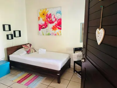 a bedroom with a bed and a painting on the wall at Boutique Hotel Casa de Lis, Turrialba in Turrialba
