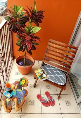 a porch with a chair and a potted plant and slippers at Boutique Hotel Casa de Lis, Turrialba in Turrialba