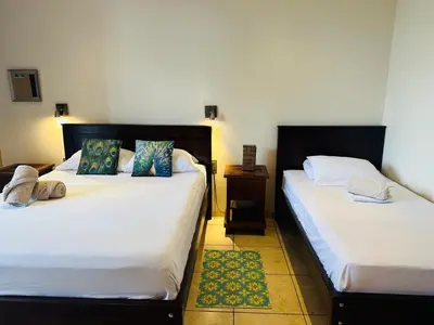two beds sitting next to each other in a room at Boutique Hotel Casa de Lis, Turrialba in Turrialba