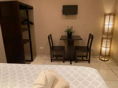 a dining room with a table and chairs and a television at Boutique Hotel Casa de Lis, Turrialba in Turrialba