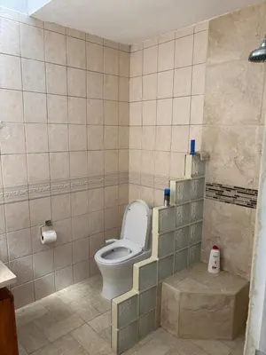 a bathroom with a toilet in a tiled room at Casa 8C Jaco Sol in Jacó