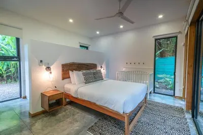 a bedroom with a bed and a large window at Casita Pacífico Stunning Jungle Home in K-Section in Nicoya