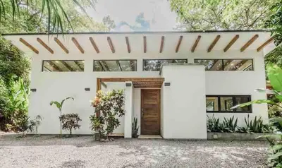 a white house with a white facade at Casita Pacífico Stunning Jungle Home in K-Section in Nicoya