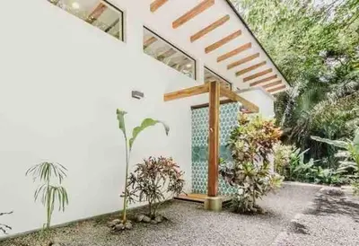 a white house with plants in the courtyard at Casita Pacífico Stunning Jungle Home in K-Section in Nicoya