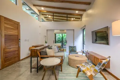 a living room with a couch and a table at Casita Pacífico Stunning Jungle Home in K-Section in Nicoya