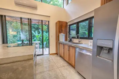 a large kitchen with a sink and a dishwasher at Casita Pacífico Stunning Jungle Home in K-Section in Nicoya