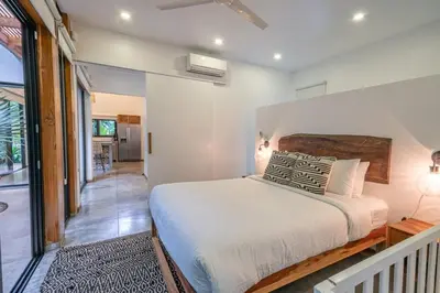a bedroom with a large bed and a hallway at Casita Pacífico Stunning Jungle Home in K-Section in Nicoya