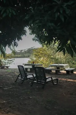 two chairs and a picnic table next to a lake at Dominical Long Term Rental in Savegre