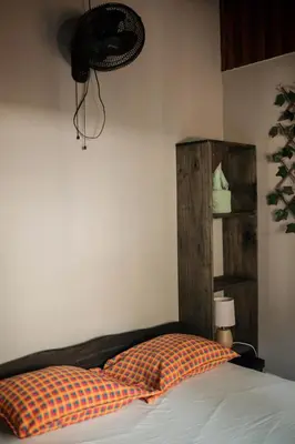 a bedroom with a bed with a pillow and a fan at Dominical Long Term Rental in Savegre