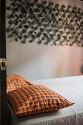 a pillow sitting on a bed next to a wall at Dominical Long Term Rental in Savegre