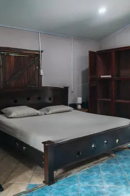 a bedroom with a large bed with a wooden headboard at Dominical Long Term Rental in Savegre