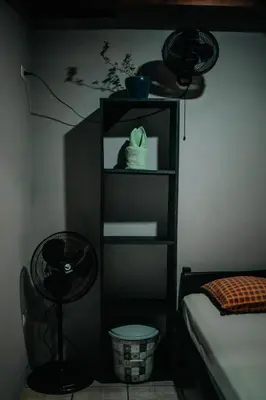 a room with a bed and a shelf with dishes at Dominical Long Term Rental in Savegre