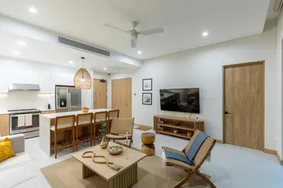 a living room with a table and a kitchen at Pura Vida Peaceful Condo At Become Nosara in Nicoya