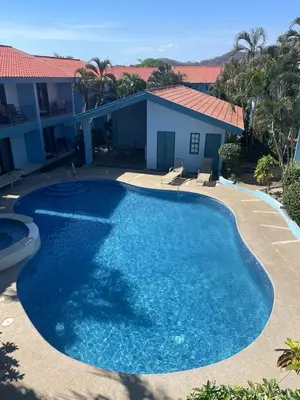a large blue swimming pool in front of a house at Pineapple Condo at Villa Riviera in Coco