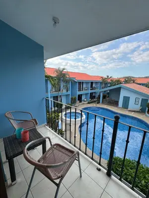 a balcony with a view of a swimming pool at Pineapple Condo at Villa Riviera in Coco