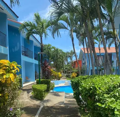 a resort with a swimming pool and palm trees at Pineapple Condo at Villa Riviera in Coco