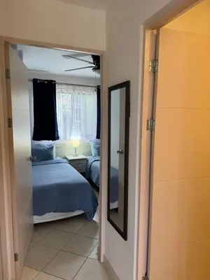 a bedroom with a mirror and a bed and a window at Sunscape Second Floor Condo with Rooftop in Coco