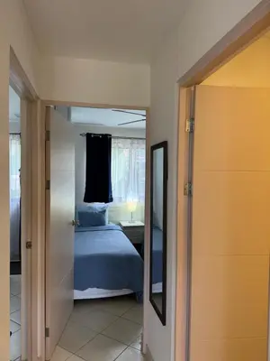 a bedroom with a bed and a mirror at Sunscape Second Floor Condo with Rooftop in Coco