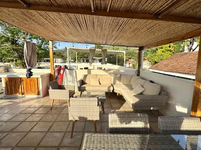 a patio with couches and chairs under a roof at Sunscape Second Floor Condo with Rooftop in Coco
