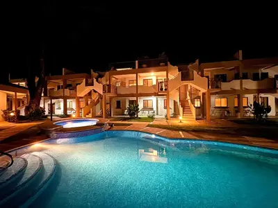 a large swimming pool in front of a building at night at Sunscape Second Floor Condo with Rooftop in Coco